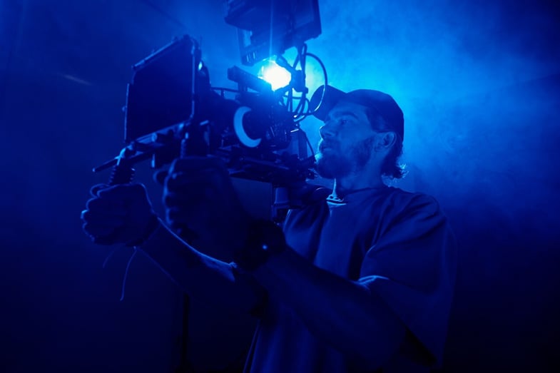 young-man-in-casualwear-holding-video-camera-while-2023-11-27-05-22-15-utc Large